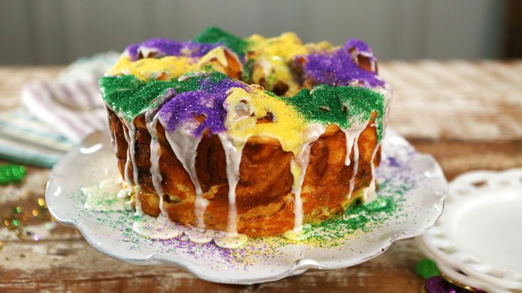 a bundt cake covered in icing and colored sprinkles on a plate