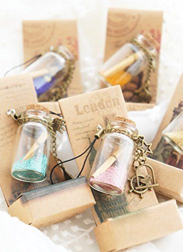 small glass bottles filled with colorful liquid on top of a white cloth covered tablecloth