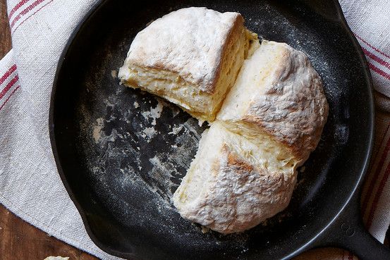 two pieces of bread sitting in a frying pan on top of a wooden table