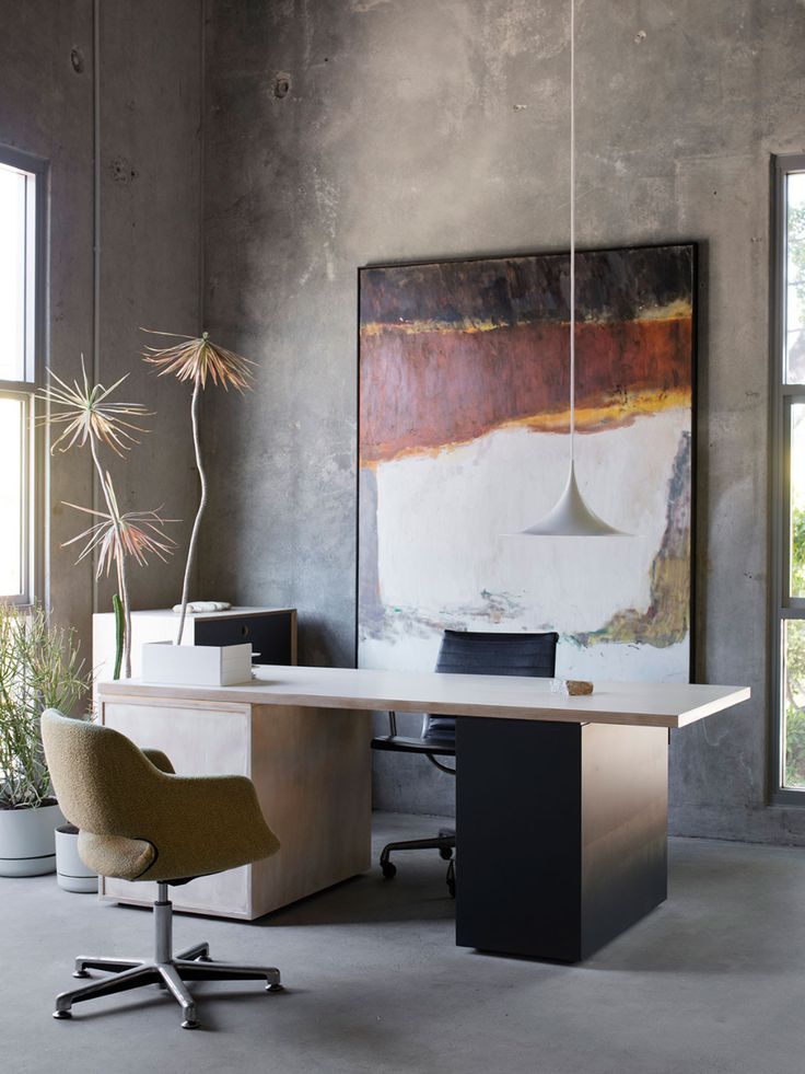 an office with a large painting on the wall