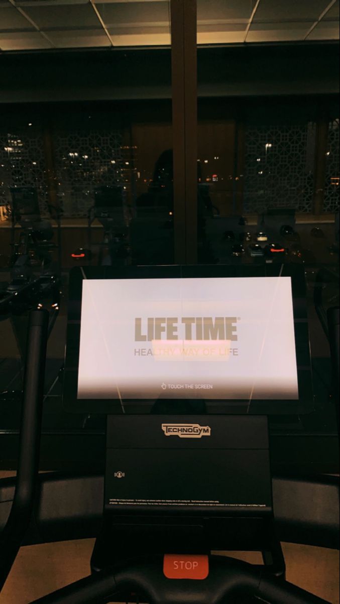 there is a sign that says life time on the treadmill in front of a window