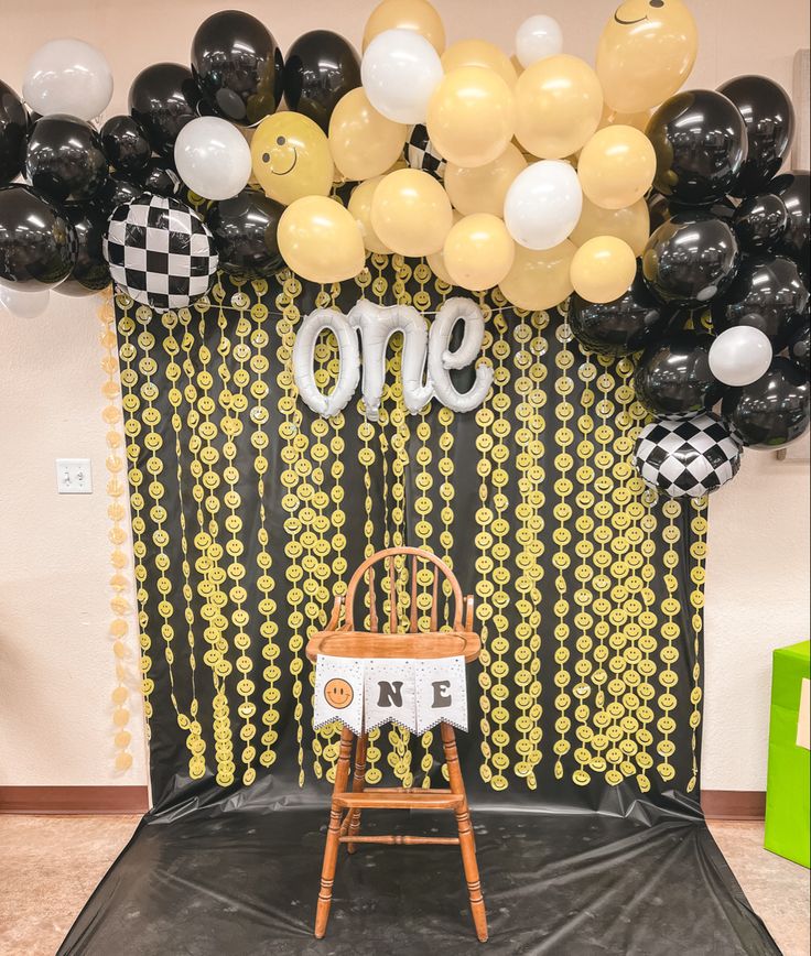 a chair sitting on top of a black and white stage with balloons in the background