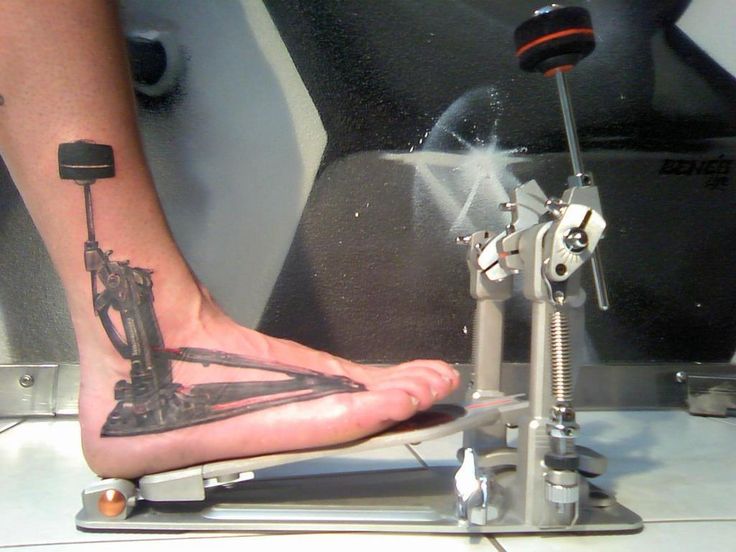 a person's foot with a tattoo on it and a machine in the background