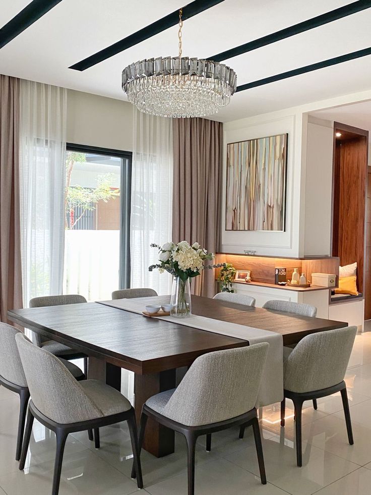 a dining room table with chairs and a chandelier hanging from it's ceiling