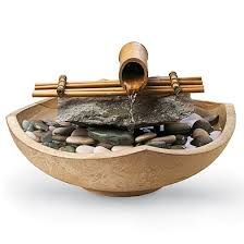 a bowl filled with rocks and water pouring out of it