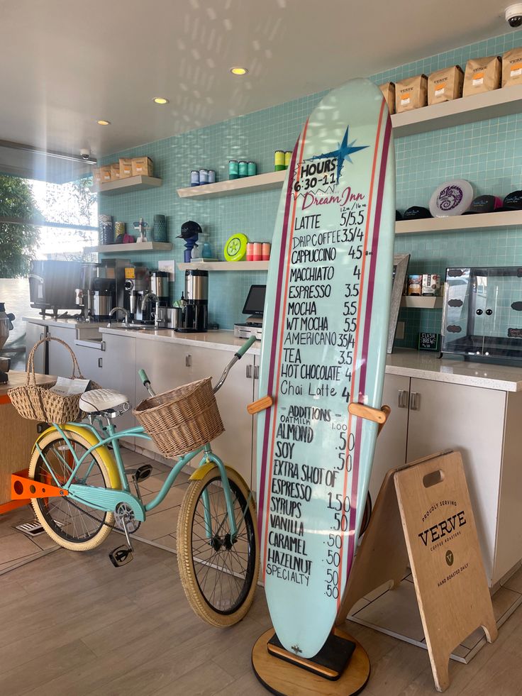 a surfboard sitting on top of a wooden stand next to a bike in a kitchen