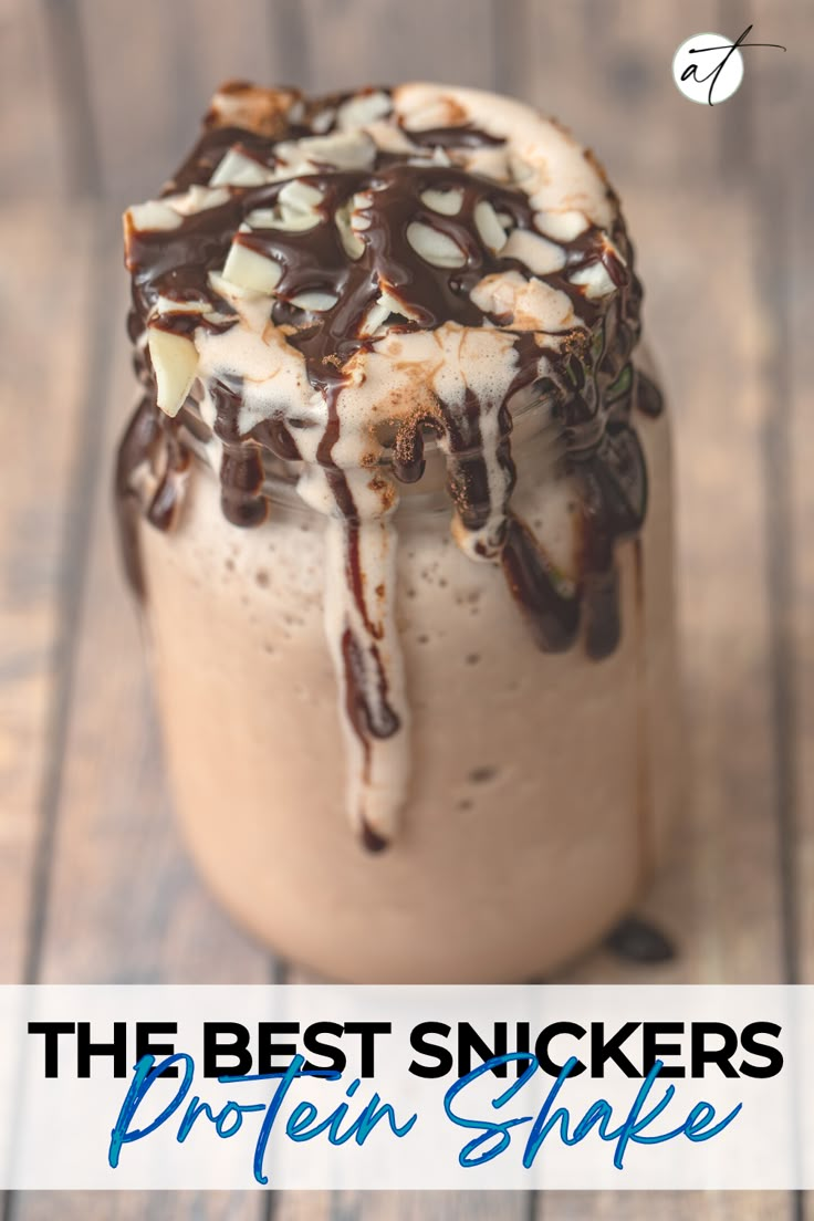 the best snickkers protein shake recipe in a glass with chocolate drizzle on top