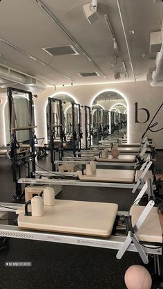 a gym with rows of exercise equipment and mirrors on the wall, all lined up