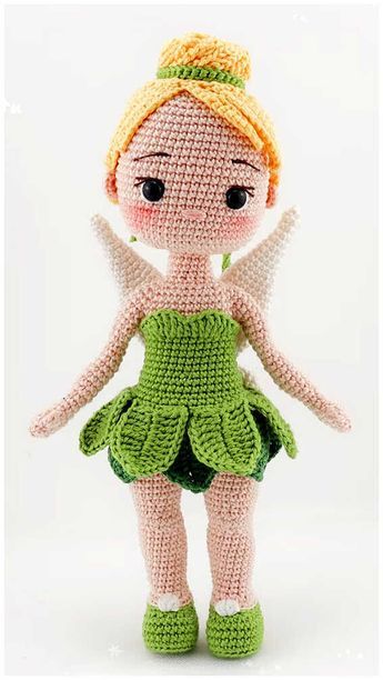 a crocheted doll is wearing a green dress and holding her hands in the air