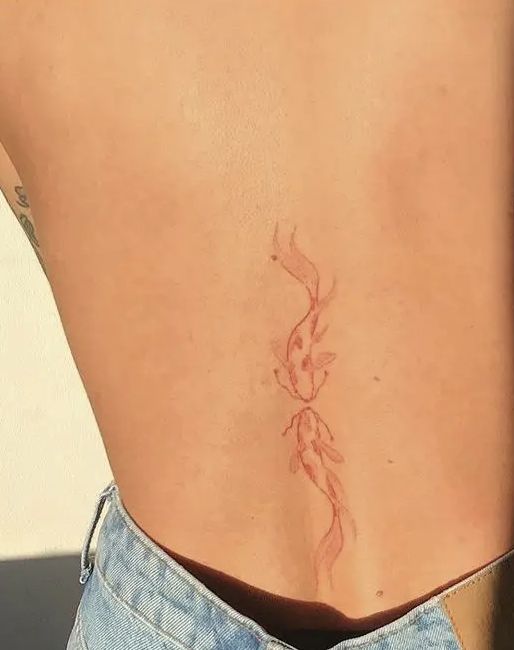 the back of a woman's stomach with a small tattoo on her left side