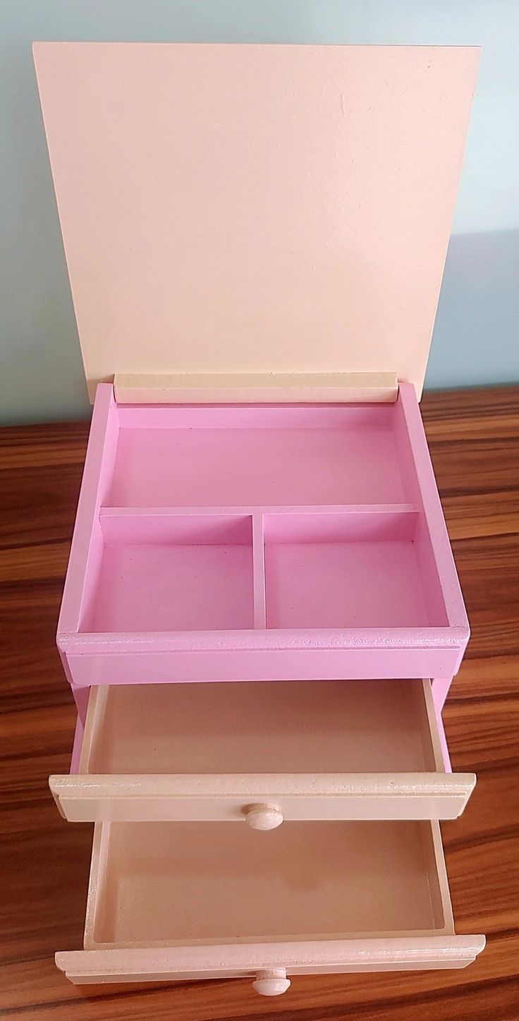 a pink toy chest sitting on top of a wooden floor