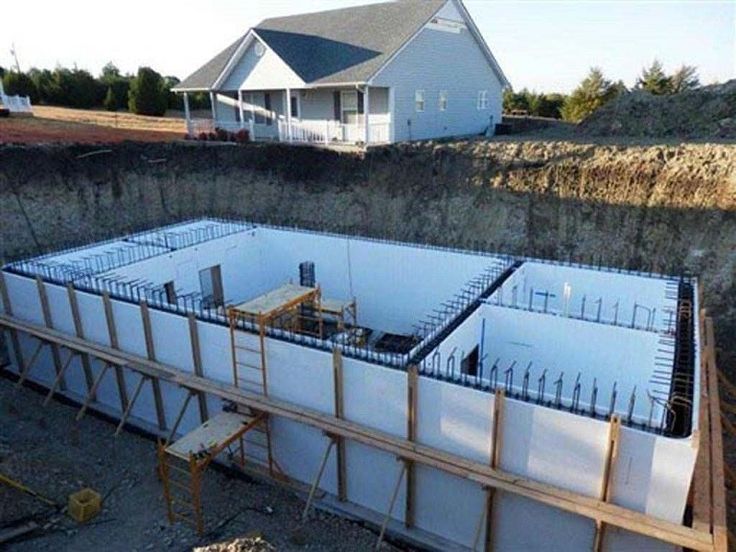 an unfinished house under construction in the middle of a rural area with a large foundation