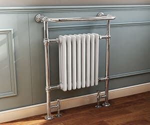 a white radiator sitting on top of a wooden floor next to a wall