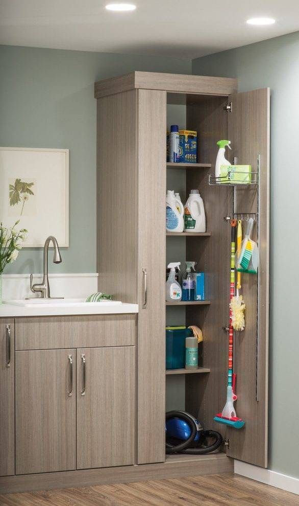 a bathroom with a sink, cabinets and cleaning supplies on the shelves in front of it