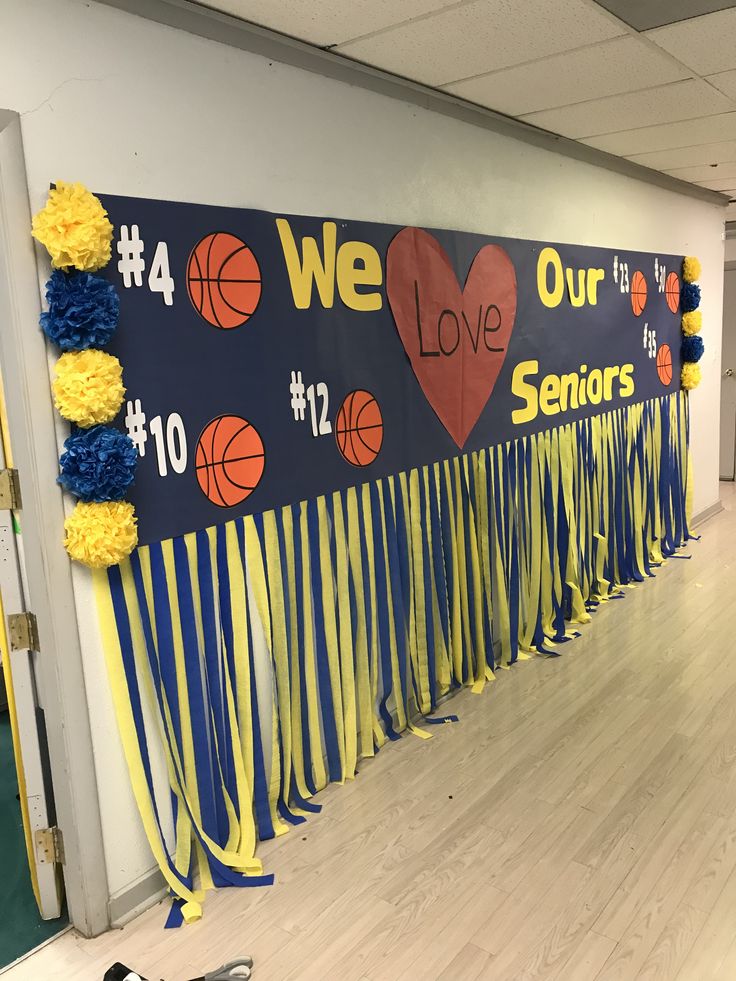 a hallway decorated with banners and streamers in the shape of basketballs, hearts, and numbers