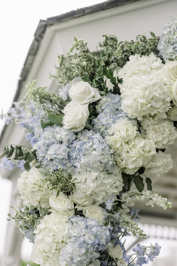 a bouquet of white and blue flowers in front of a building