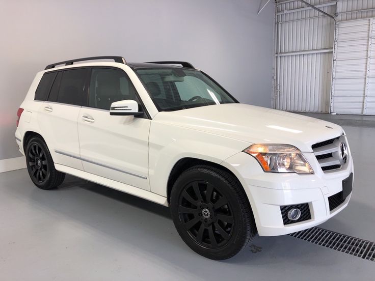 a white mercedes glk is parked in a garage with black wheels and rims