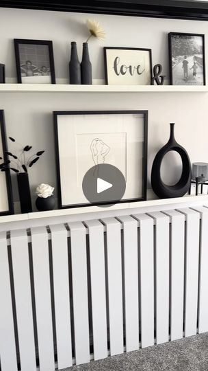 a white radiator sitting next to a wall filled with pictures and vases