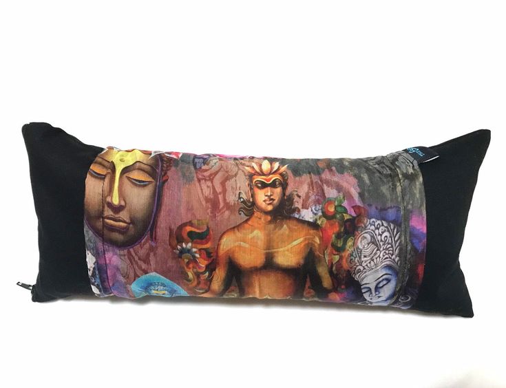 a black pillow with an image of a man and two masks on it's side