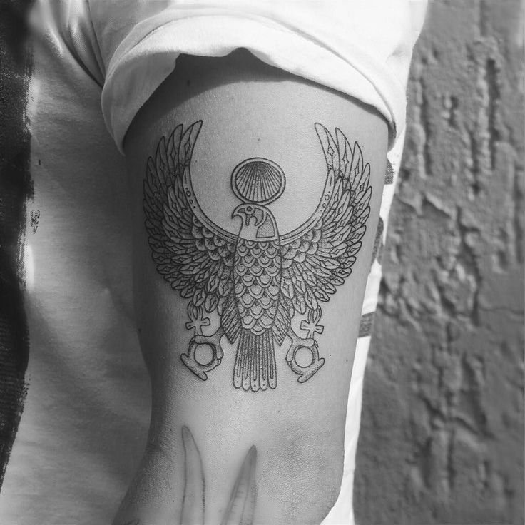 a black and white photo of a person's arm with an eagle tattoo on it