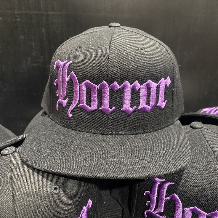 "HORROR HAT Black Snapback Hat Purple Embroidery On Black Hat BLACK Under-Bill 80% Acrylic / 20% Wool Suggested Size Range: Fits hat sizes: 7 - 7 3/4 (22\"-24.25\")" Black Embroidered Flat Bill Fitted Hat, Purple Curved Brim Baseball Cap For Streetwear, Purple Curved Brim Hat For Streetwear, Purple Baseball Cap For Streetwear, Embroidered Snapback Fitted Hat For Streetwear, Purple Snapback Baseball Cap, Purple Snapback Cap For Streetwear, Purple Snapback Hat For Streetwear, Embroidered Flat Brim Fitted Hat For Streetwear