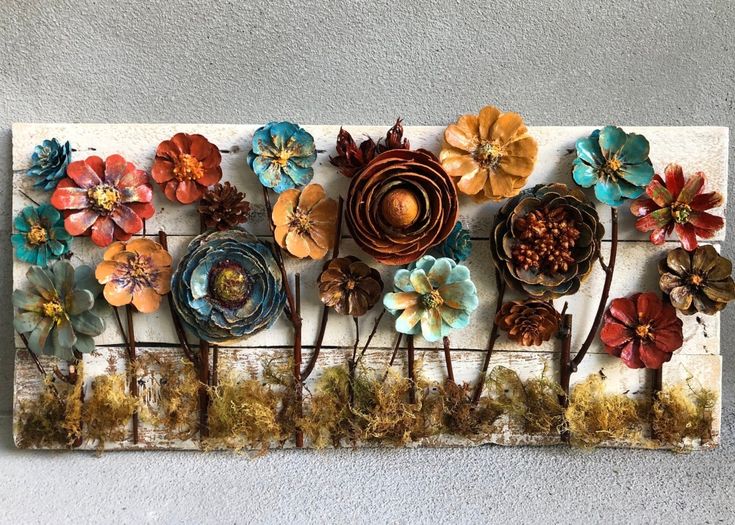 there are many different flowers on this metal wall art piece that is hanging on the wall