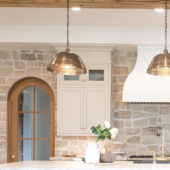 a kitchen with two pendant lights hanging from the ceiling