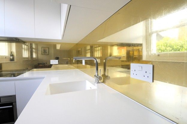 a kitchen with white counter tops next to a sink and oven in the middle of it