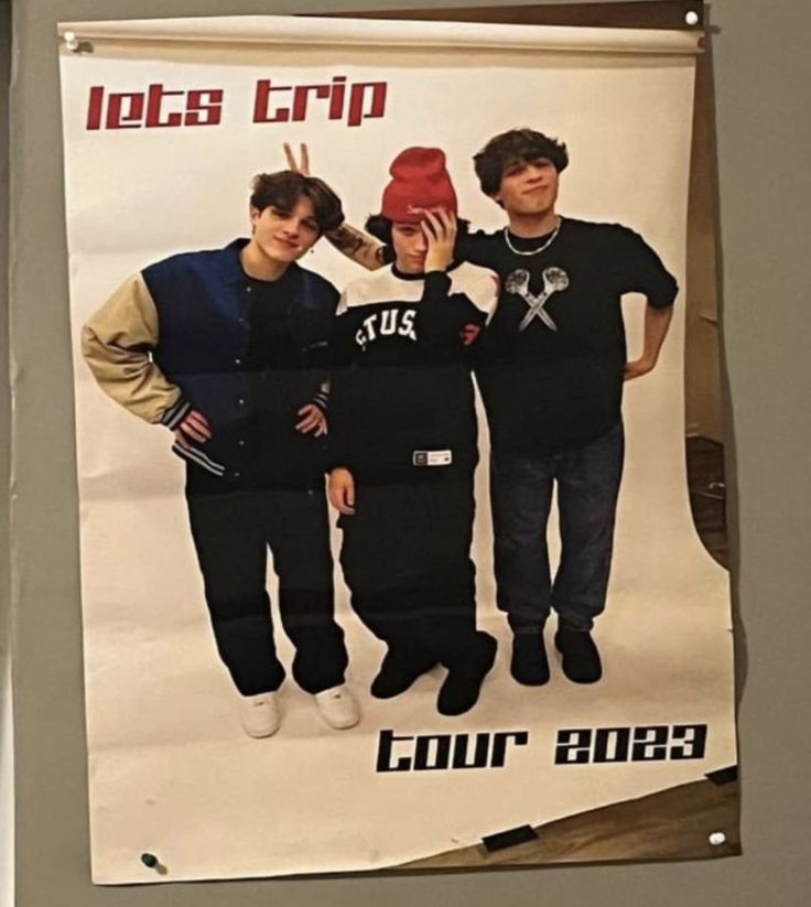 a poster hanging on the side of a wall with two boys holding up a red shoe