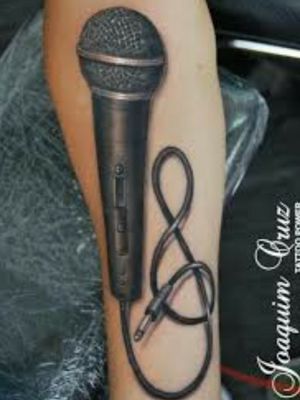 a tattoo with a microphone on it and a cord attached to the side of the arm