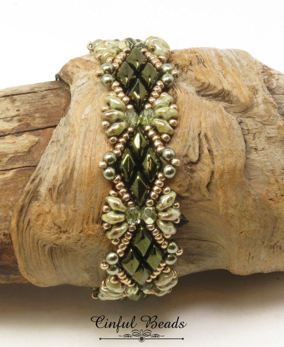 the beaded bracelet is sitting on top of a piece of wood