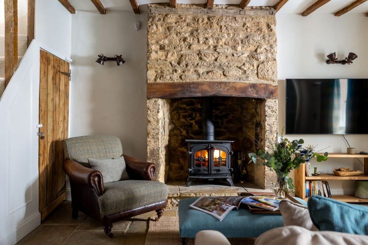 a living room filled with furniture and a fire place next to a wall mounted tv