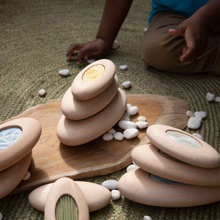 a child playing with wooden toys on the floor