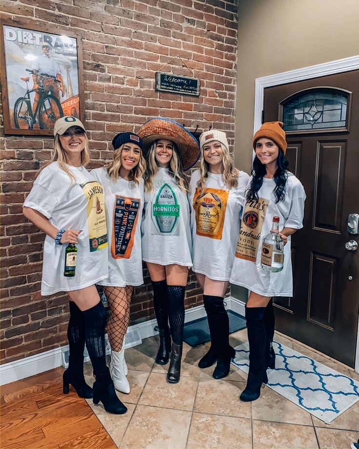 four women dressed up in costumes posing for the camera with beer bottles on their backs