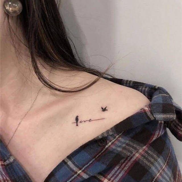 a woman with a small tattoo on her chest that has birds flying in the sky