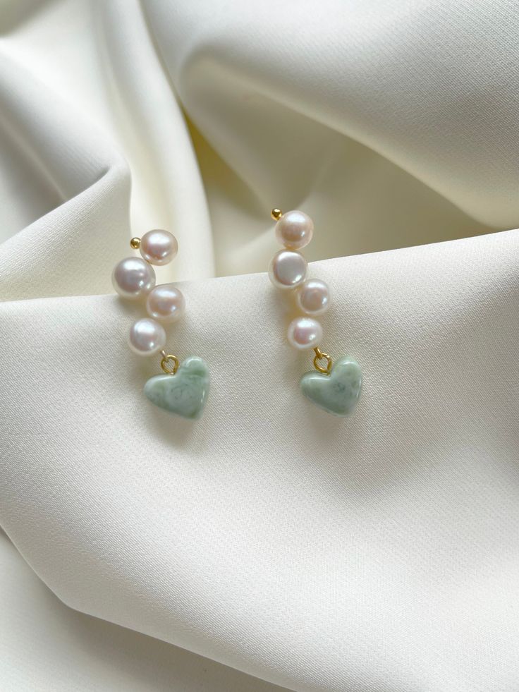 Woven freshwater pearls with a sage-white swirl heart charm. 
 - Pearl stud woven with 4 round freshwater pearls - 1/2" resin heart charm in a sage green and white swirl finish  - 18k gold plated brass 
 
 - Each order comes in a velvet pouch in our signature box, perfect for gifting Elegant Green Earrings With Heart Charm, White Heart-shaped Pearl Earrings Gift, Green Pearl Jewelry For Gifts, Pearl White Heart-shaped Pearl Drop Jewelry, Green Pearl Earrings As Gift, Green Pearl Earrings For Gift, Handmade Green Pearl Earrings For Gift, Green Pearl Drop Jewelry For Gifts, Green Pearl Drop Jewelry As Gift