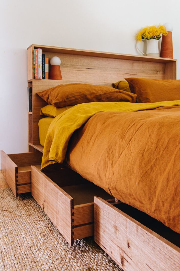 a bed with two drawers underneath it and a yellow bedspread on the bottom