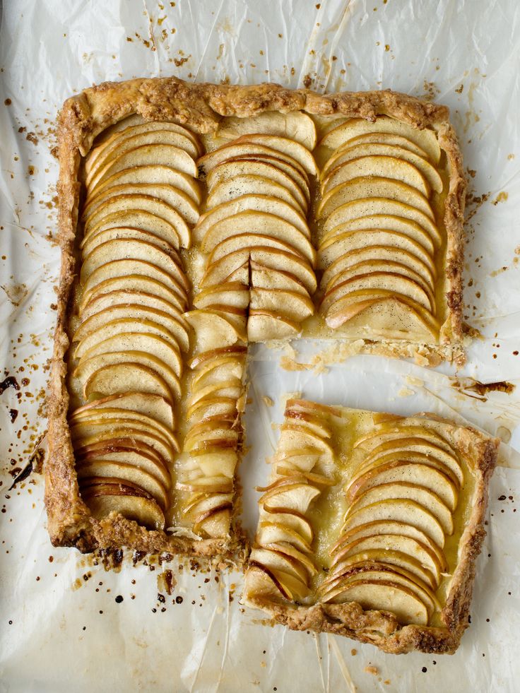 two slices of apple pie sitting on top of parchment paper