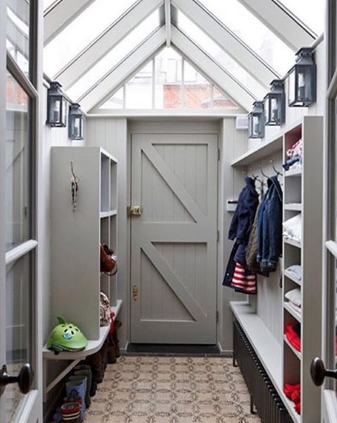 a walk in closet with an open door and shelves filled with coats, shoes and other items