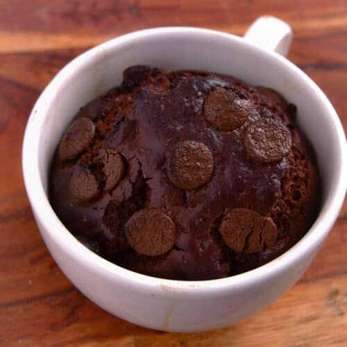 a white bowl filled with chocolate pudding on top of a wooden table