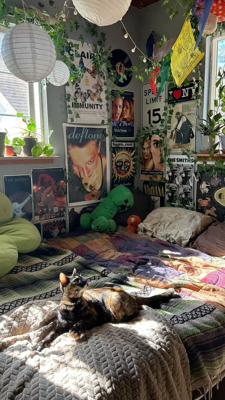 a cat laying on top of a bed in a room filled with posters and plants