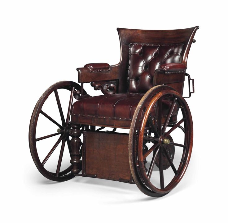 an old fashioned wooden chair with leather upholstered back and arm rests on wheels