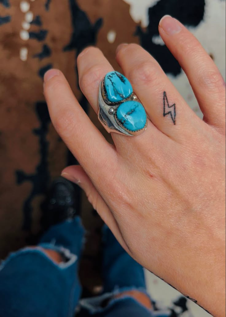 a woman's hand with a turquoise ring on it