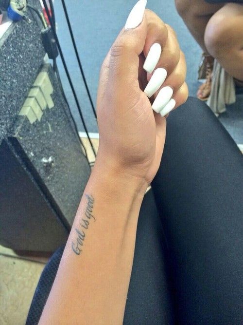 a woman's arm with a small tattoo on the wrist and her name written in cursive writing