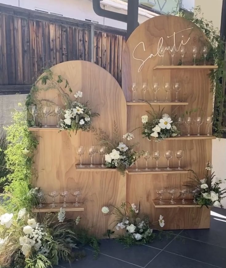 a wooden display with flowers and wine glasses