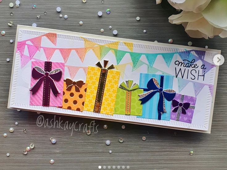 a card with some bows on it and confetti in the back ground next to flowers