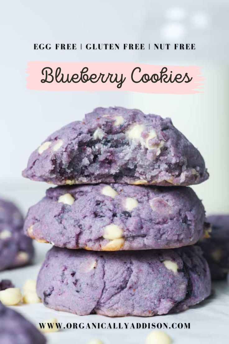 three blueberry cookies stacked on top of each other with white chocolate chips around them