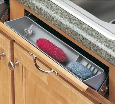 an open drawer in the middle of a kitchen with two towels and a red ball on it