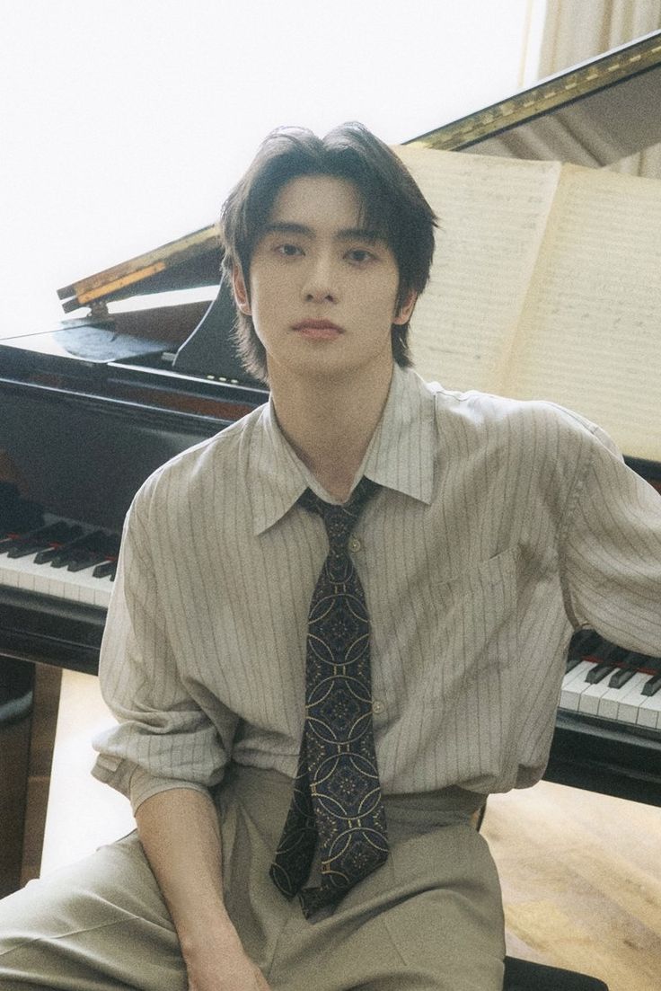 a young man sitting in front of a piano