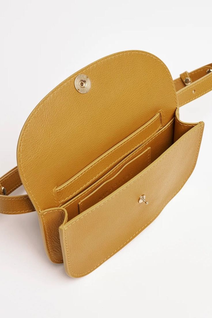 Modeled on the shape of a bean, the Faba bag is as versatile as its namesake, and can be worn either on the waist or across the chest. The Faba features a brass pull release closure, and has an interior partition and credit card pocket with our signature curve to organize your essentials. It is lithe and light enough to accompany you everywhere. Sizing + Details → Handmade In Rhode Island 4" H x 7.5" W x 1.5" D Strap Length Variable 26"-35" Leather Belt Bag With Gold-tone Hardware For On-the-go, Leather Belt Bag With Gold-tone Hardware In Pouch Shape, Leather Belt Bag With Gold-tone Hardware, Gold Crossbody Saddle Bag With Adjustable Strap, Chic Gold Belt Bag With Removable Pouch, Gold Belt Bag With Removable Pouch For Daily Use, Brown Belt Bag With Gold-tone Hardware, Gold Leather Crossbody Belt Bag, Elegant Gold Belt Bag For Everyday Use